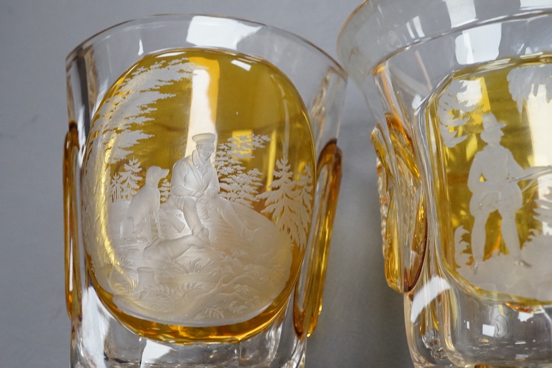Four Bohemian engraved amber or ruby flashed ‘hunting’ goblets or beakers, late 19th century, tallest 15cm high
